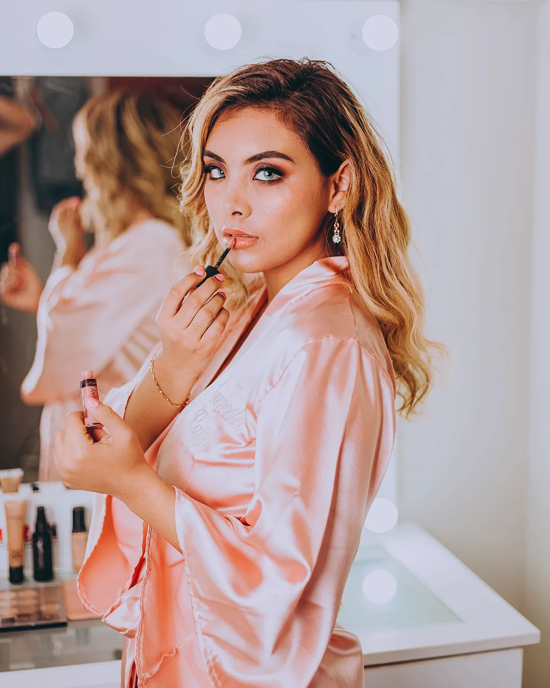 Sesión de beauty: retoque de maquillaje frente al espejo de camerino
