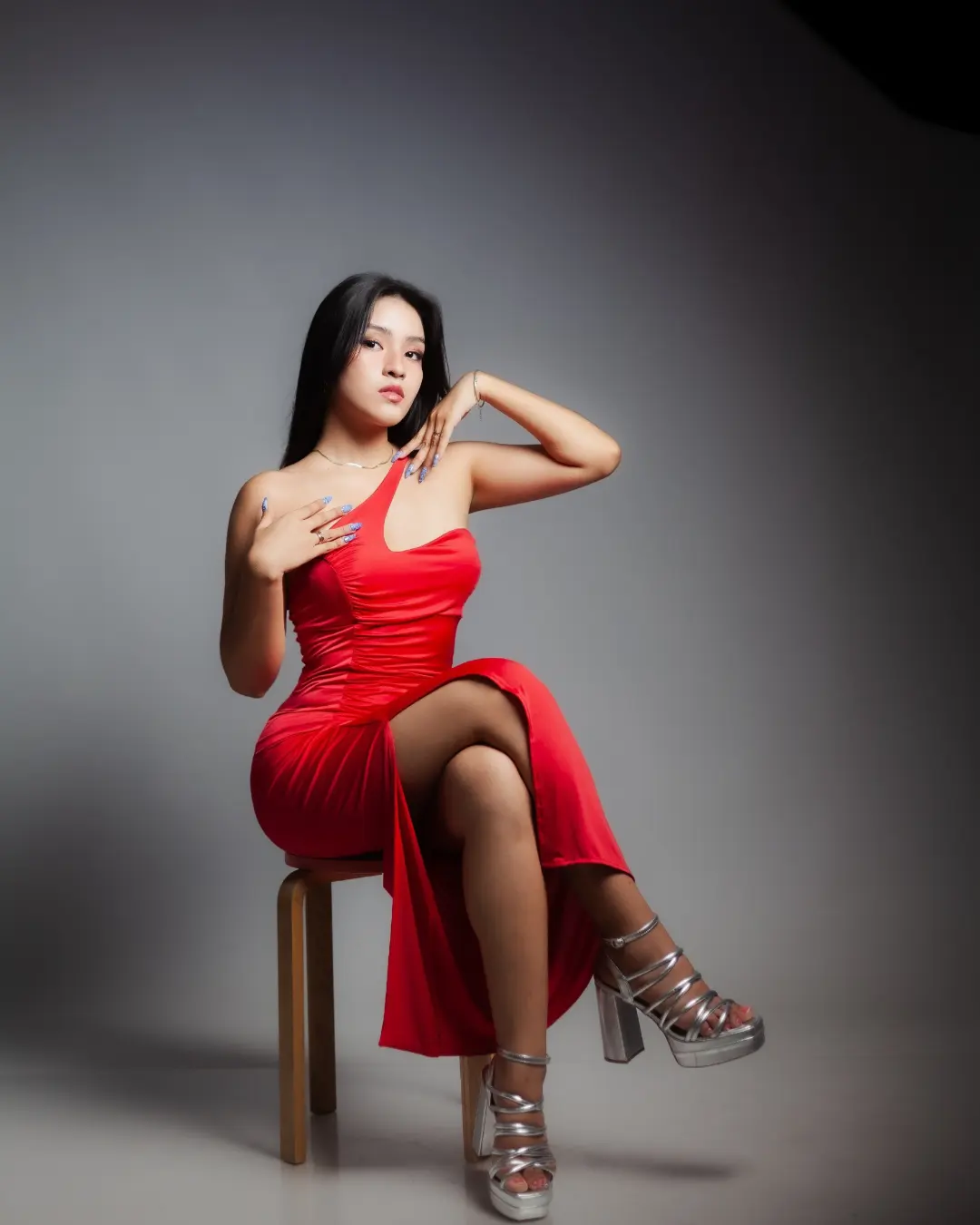 Sesión de moda: mujer con vestido rojo en estudio con luz suave