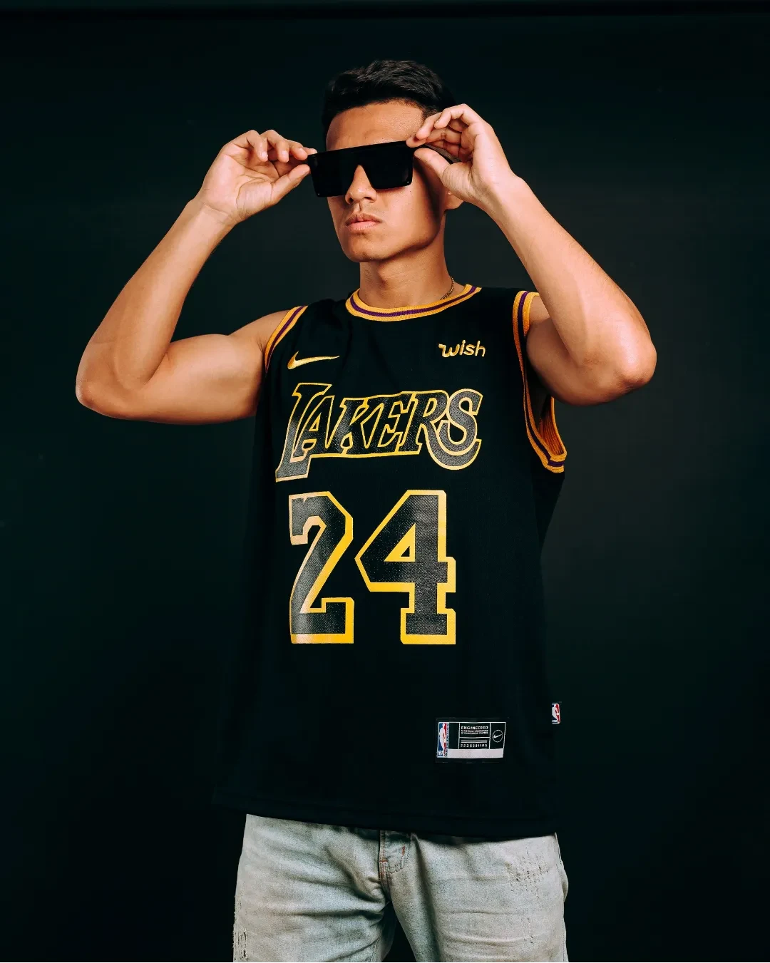 Retrato urbano de un joven con lentes de sol y fondo oscuro